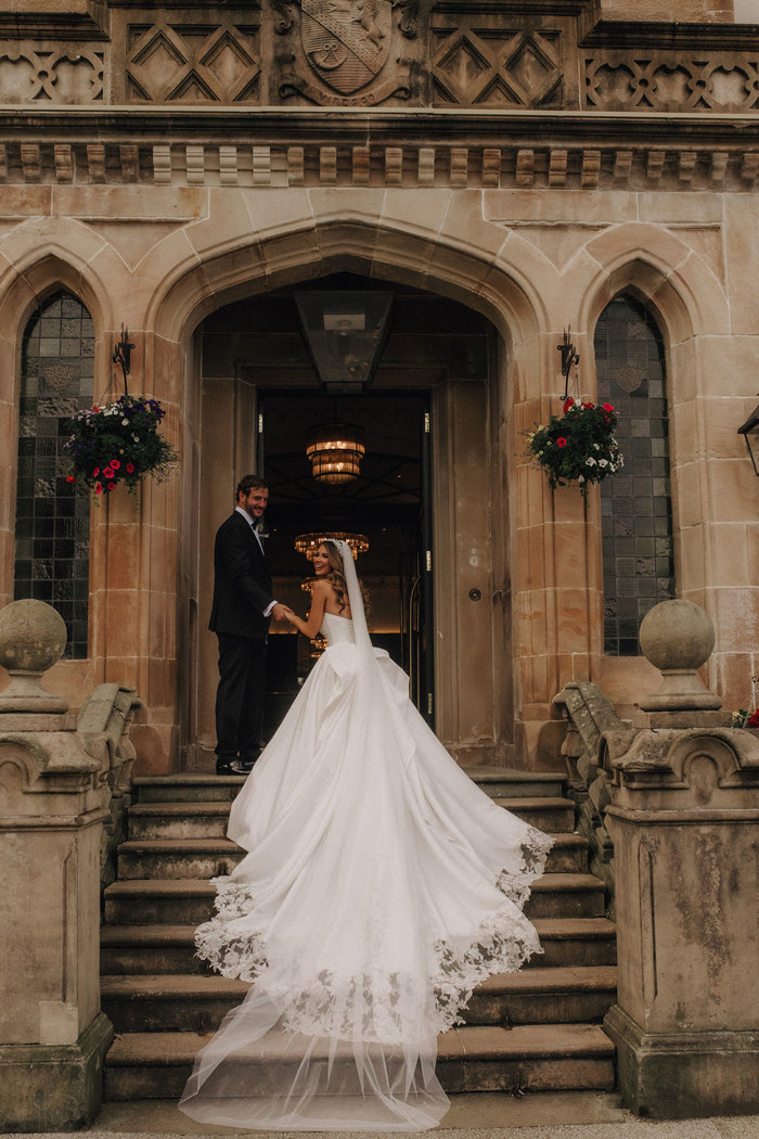 a bride and groom pose on a set of stone steps outside Cameron House.