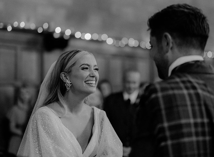 a bride smiles joyfully wearing a sparkling Rosie dress by Eva Lendel and earrings by Untamed Petals