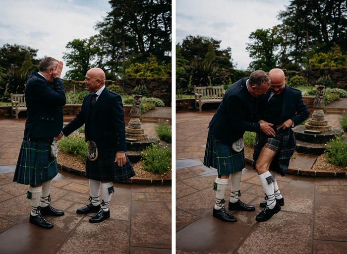 first look of two grooms in an ornamental garden wearing kilts on their wedding day