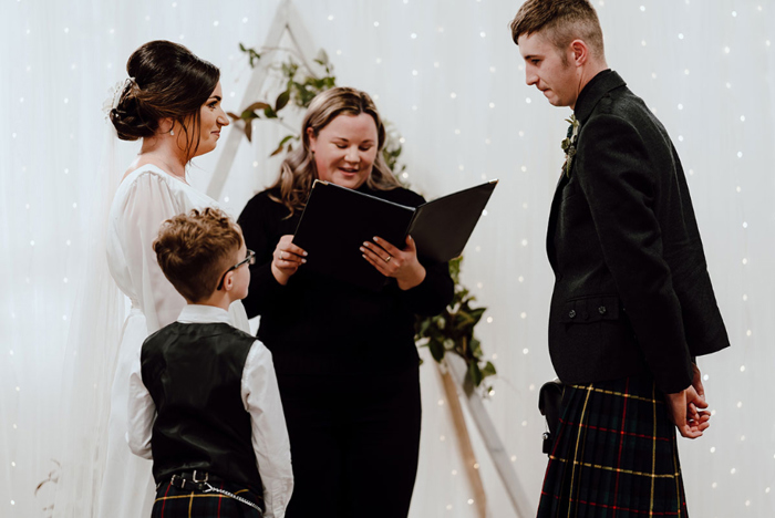 Bride and groom listen to a reading during their ceremony