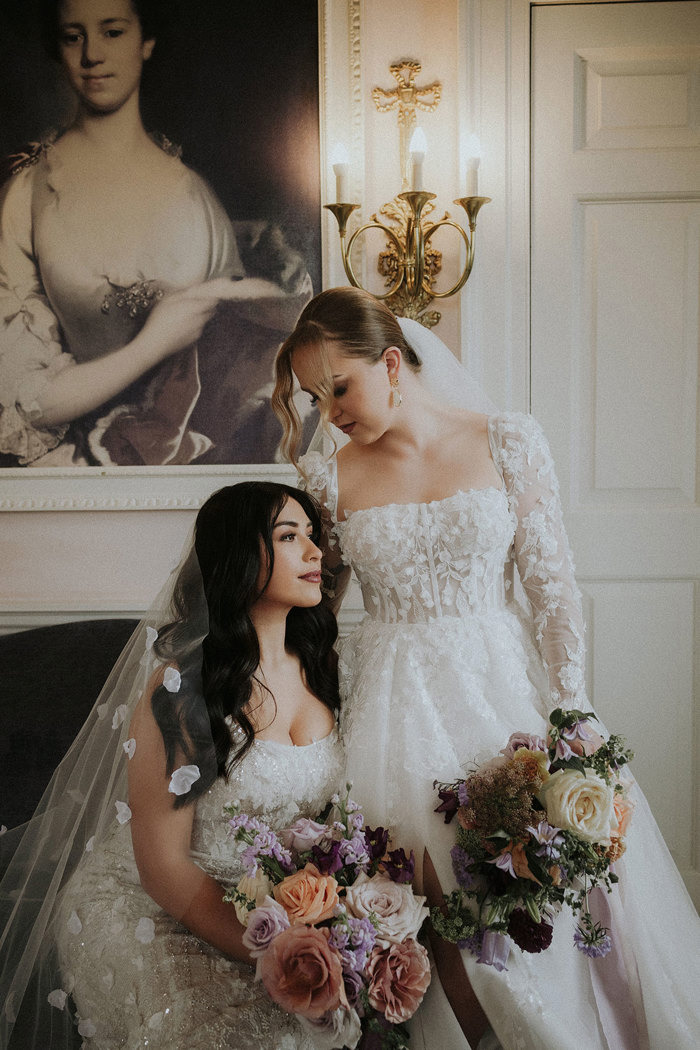 brides sitting down holding flower bouquets Chatelherault shoot