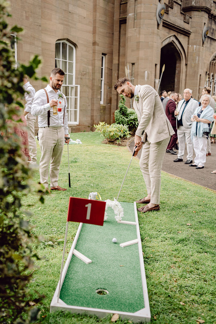 guests play outdoor mini golf during drinks reception at drumtochty castle
