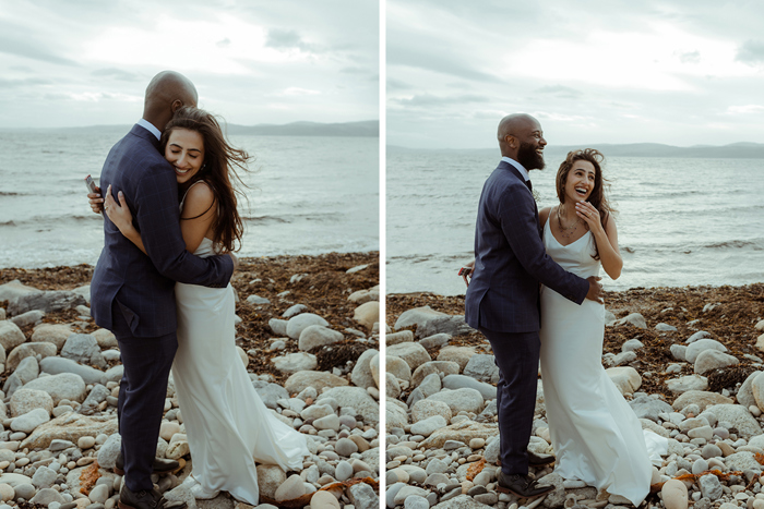 A Bride And Groom Embracing On A Stone Beach On Arran