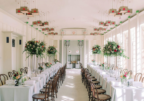 Charles Rennie Mackintosh-designed Music Room at House for an Art Lover set for dinner with long tables, elegant dark wood chairs and raised flower arrangements