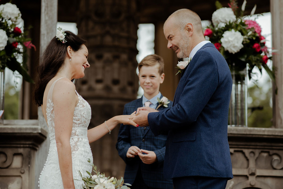 Groom puts ring on the brides finger during the ceremony at The Restoration Yard