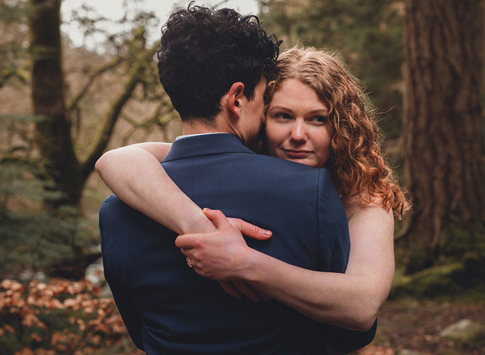 Two women hugging with one facing the camera and one facing away