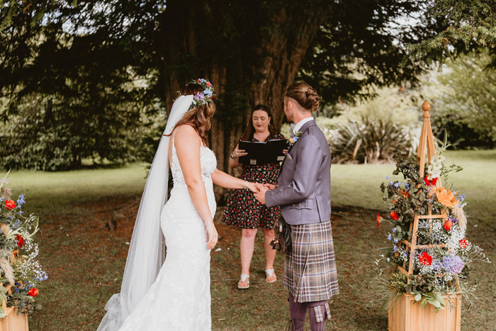 Couple hold hands during ceremony