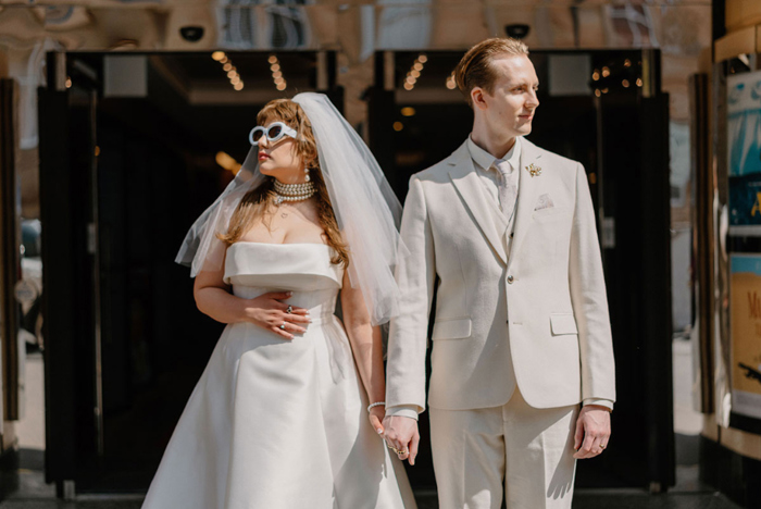 Couple portrait showing the pair holding hands and looking away from each other