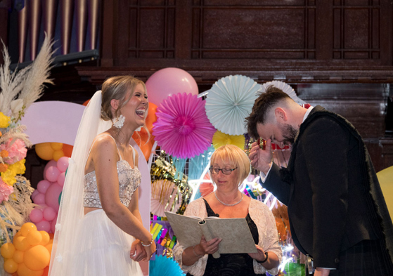 Bride and groom laugh during their wedding ceremony at St Luke's Glasgow