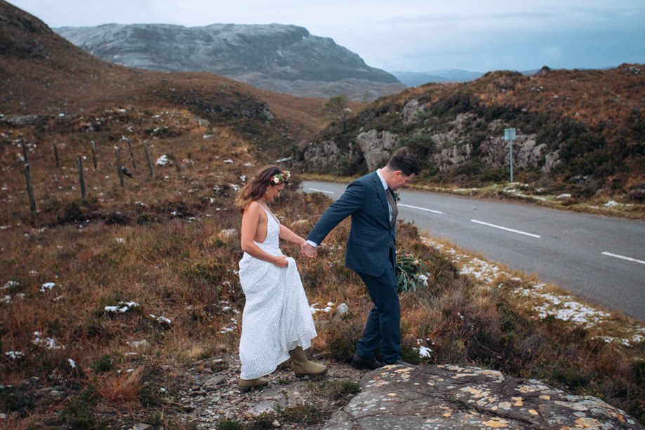 Couple climb over rugged terrain