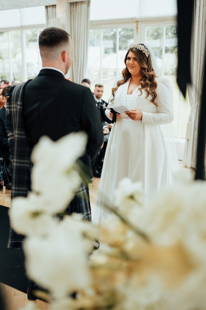 A bride reading her vows to her husband during a wedding ceremony