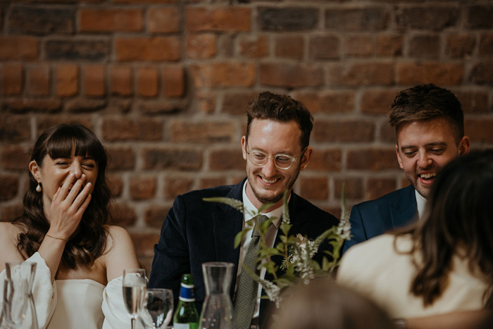 Couple sit at top table and laugh