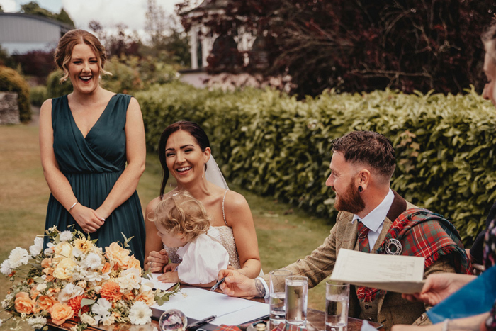 Couple laugh as they sign the register