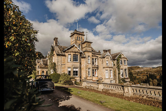 Auchen Castle exterior with a car parked in the driveway