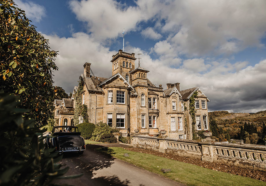 Auchen Castle exterior with a car parked in the driveway