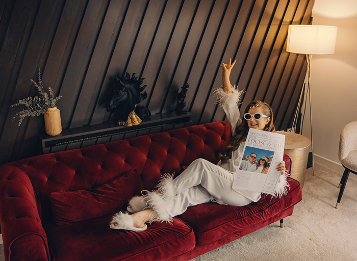  Bride Wearing White pyjamas with feathes On Red Velvet Couch