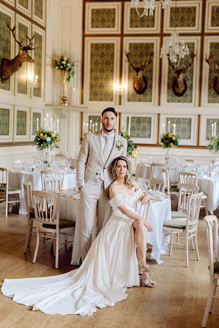 bride and groom pose for photograph during wedding dinner at drumtochty castle