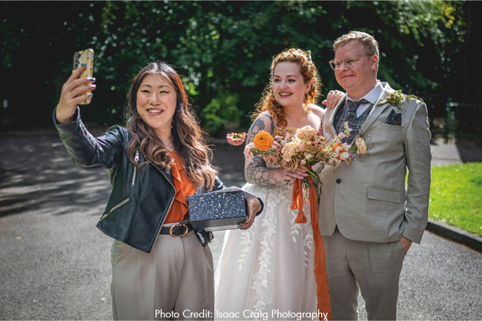 Celebrant takes photo with couple