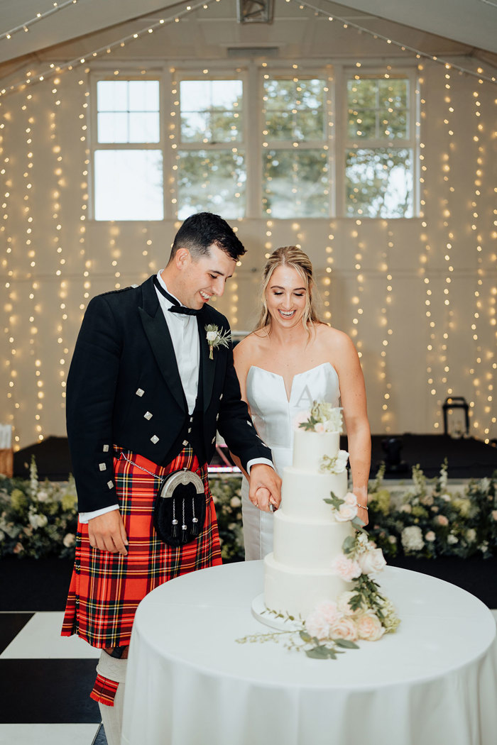 A bride and groom cutting a cake.