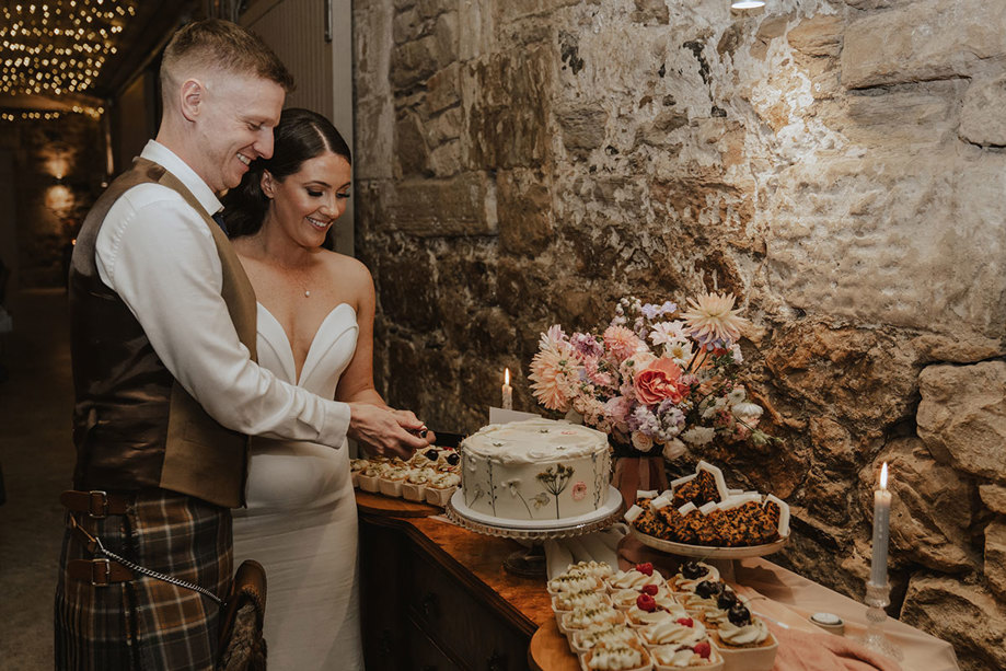 bride and groom cut wedding cake at falside mill in fife