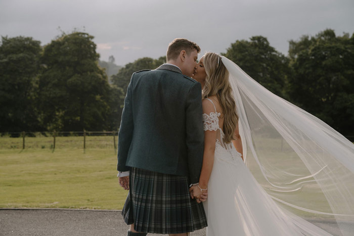 bride and groom kiss and hold hands outside cornhill castle