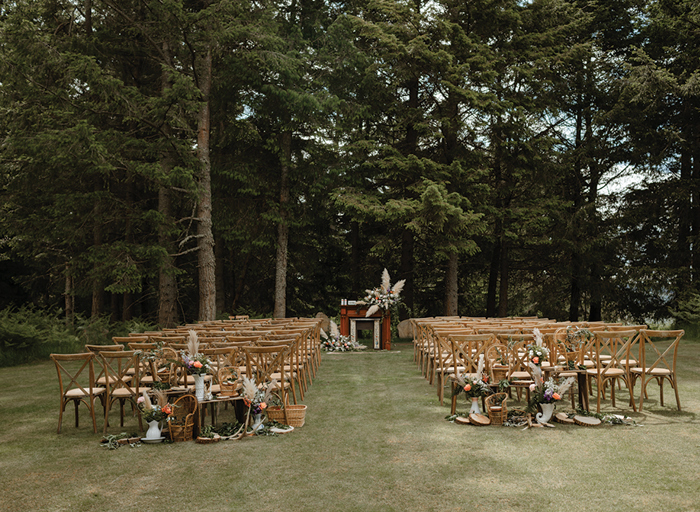 rows of chairs outside on a well trimmed lawn surrounded by trees