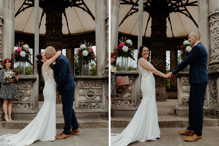 Bride and groom hold hands and share a kiss during the ceremony 