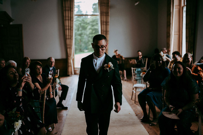 Groom walking down aisle