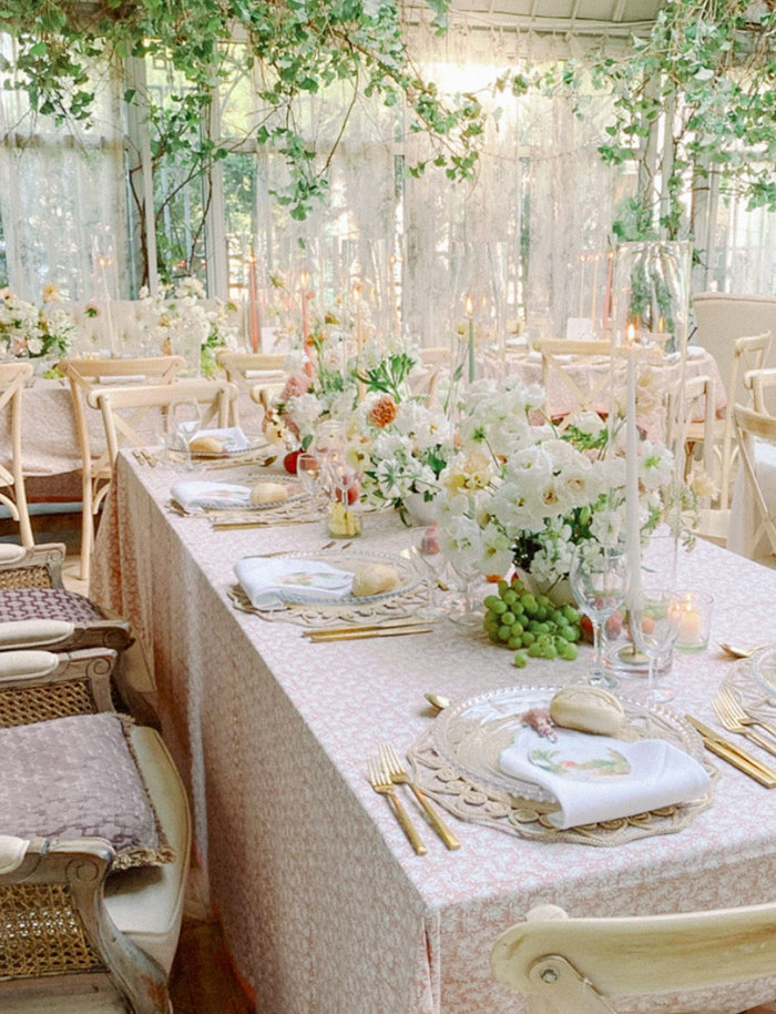 rose, gold and green themed tablescape with elegant tablecloths, candle sticks and floral arrangements