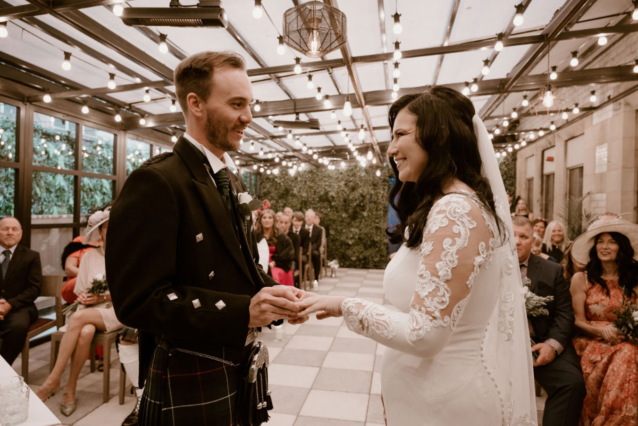 Groom puts ring on the brides finger during the ceremony