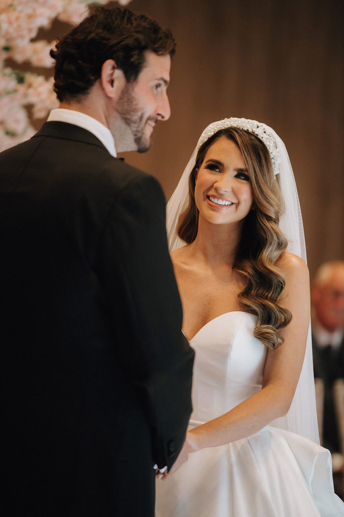 a bride looks up towards a groom during a wedding ceremony.