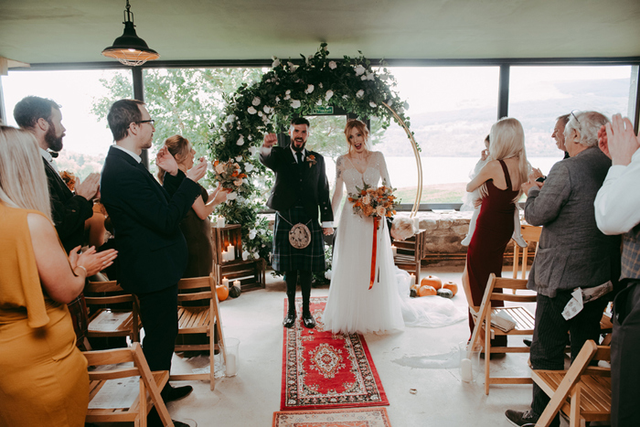 Bride and groom walk up the aisle as newlyweds