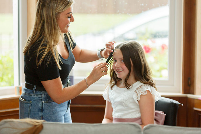 A woman combing a little girl's hair