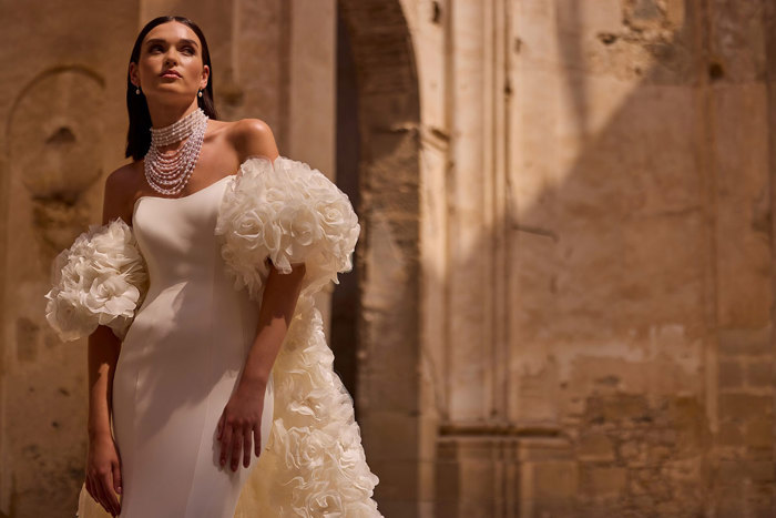 A person wearing a white dress. Veni Infantino Bridal Endless Love Collection