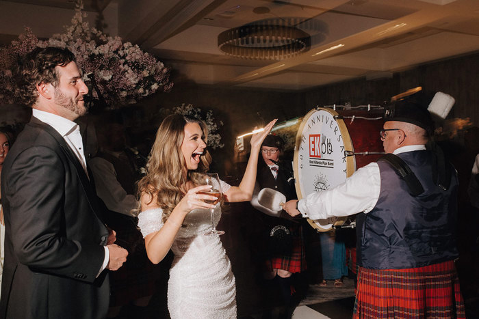 a bride and groom with pipe band drummer.