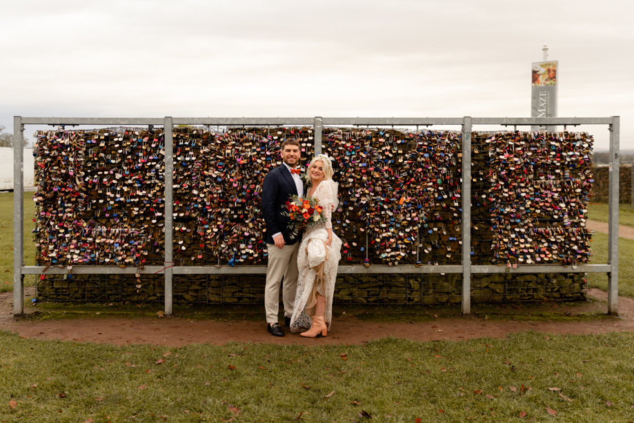 bride and groom against padlock backdrop at Gretna Green 