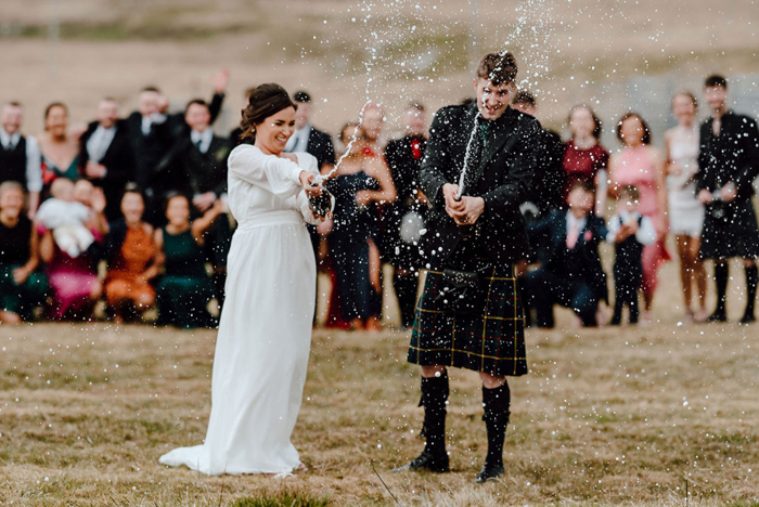 Bride and groom spraying champagne