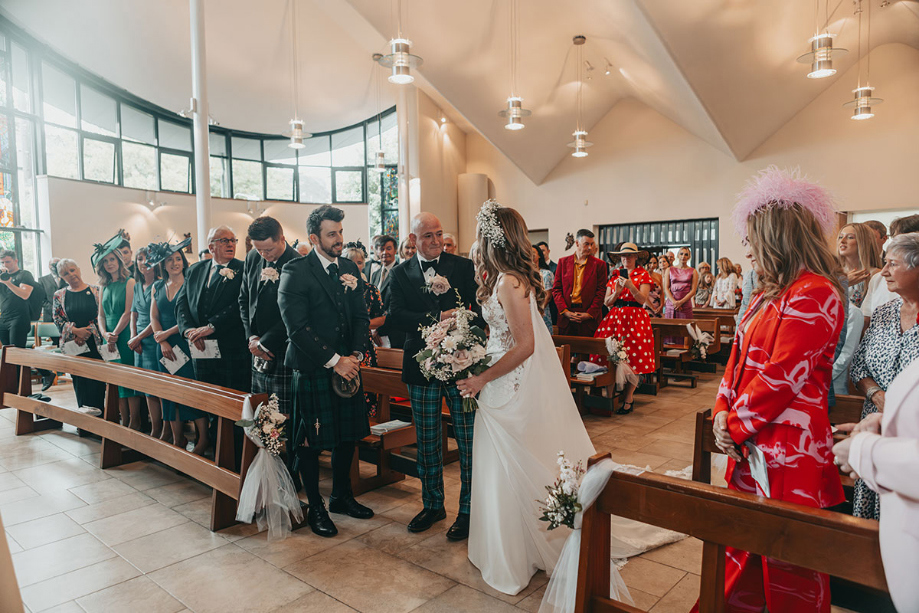 Bride and groom stand at the top of the aisle