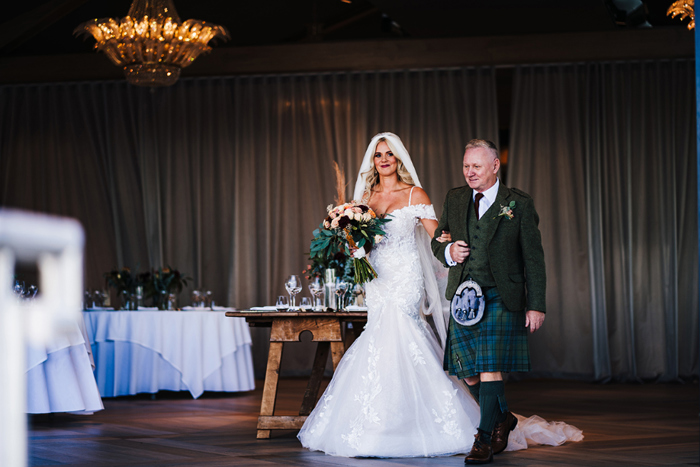 Bride is walked into reception by male guest