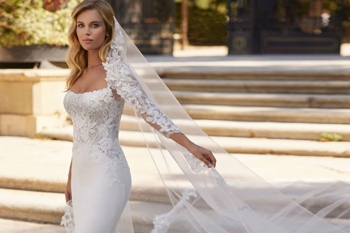 woman wearing long trailing mermaid wedding dress complete with matching veil