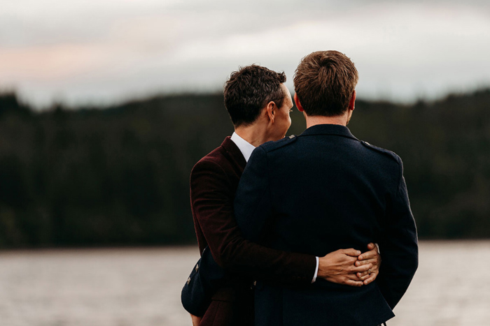 Grooms have their back to the camera and hug