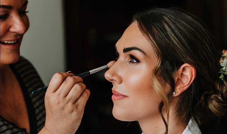 a person getting her makeup done by Leigh Blaney