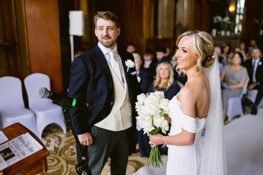 A smiling bride and groom during a wedding ceremony at Mar Hall.