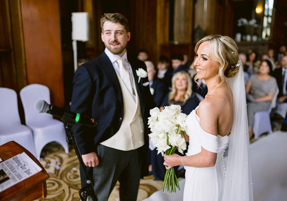 A smiling bride and groom during a wedding ceremony at Mar Hall.