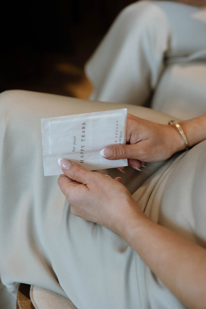 A close up of a woman holding a packet with the text 'For your Happy Tears'