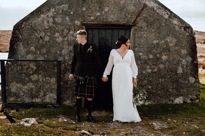 Bride and groom hold hands during couple portraits