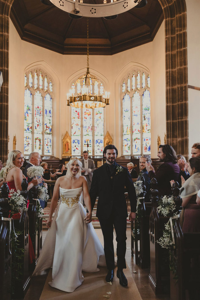 a bride and groom walking up the aisle in a church.