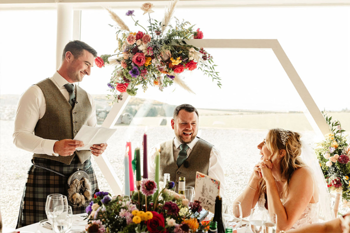 Groomsman gives wedding speech and couple laugh