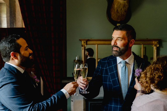 Grooms cheers their champagne flutes