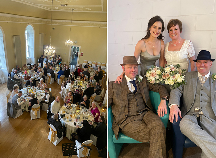 On the left a room full of round tables with wedding guests sitting at them, on the right two men in suits sit on blue chairs while a bride in a white dress and a bridesmaid in a silver dress stand behind them